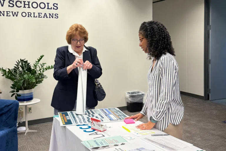 Mia Gonzales Washington speaking to a woman at a conference booth table